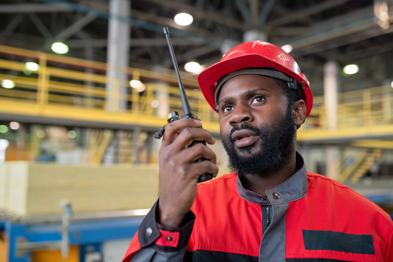 Warehouse worker holding two-way radio